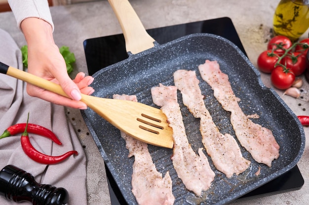 Bacon sendo cozido em frigideira grelha frigideira na cozinha doméstica