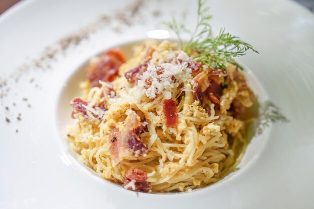 Bacon spaghetti carbonara menú de queso parmesano en plato blanco