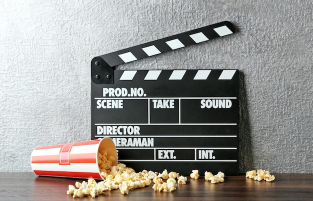 Foto badajo de película y palomitas de maíz contra el fondo de la pared gris