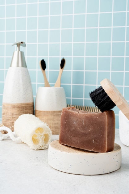 Badeaccessoires mit Bambusbürsten, handgemachter Seife, Spender und Naturbürsten auf Badewannenablage, Vorderansicht