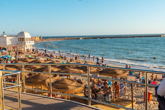 Badegäste am strand von la caleta im sommer sonnenuntergang der stadt cadiz andalusien