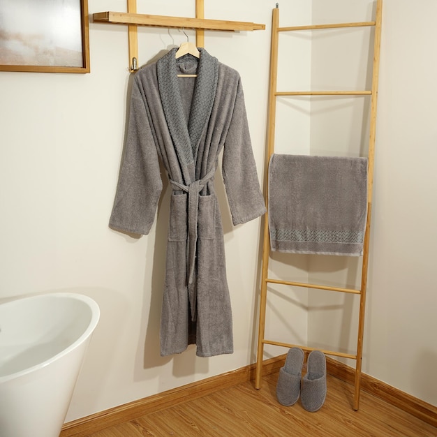 Bademantelsatz Hänger mit sauberem Bademantel und Handtuch auf leichter Wand Bademantel-Mockup