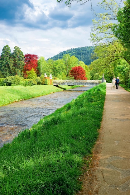 Baden Baden, Alemania - 6 de mayo de 2013: Pareja mayor en la pasarela en Gonneranlage Kurpark en la ciudad vieja de Baden Baden en Baden Wurttemberg, Alemania. Ancianos en el jardín de rosas verdes en Bath y ciudad balneario