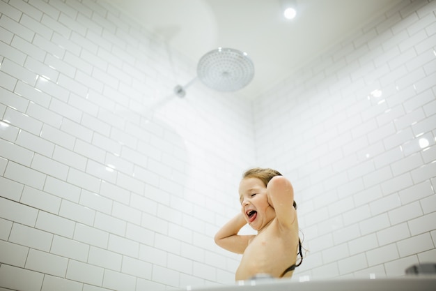 Badezeit macht Spaß. Bild des selektiven Fokus eines netten kleinen Mädchens, das ein Bad und ein Spiel nimmt