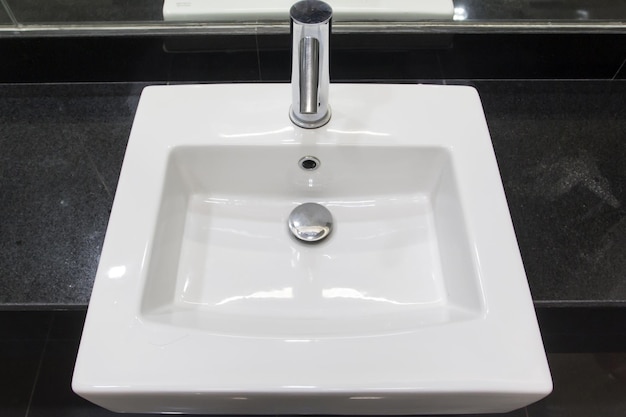 Badezimmerinterieur mit weißem Waschbecken und modernem Wasserhahn