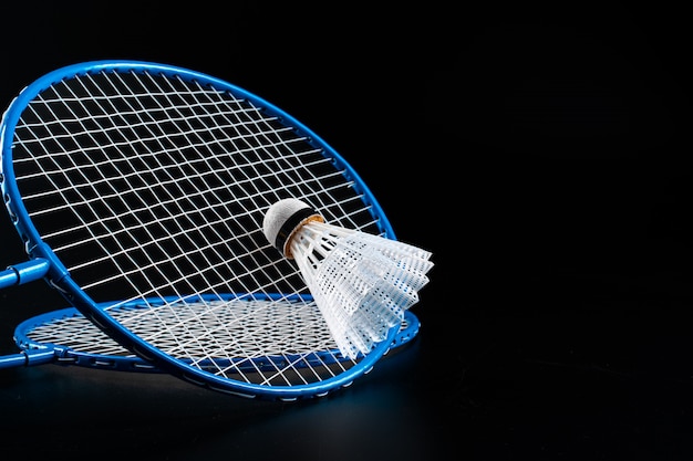 Badminton-Sportausrüstung auf dunklem schwarzem Hintergrund schließen