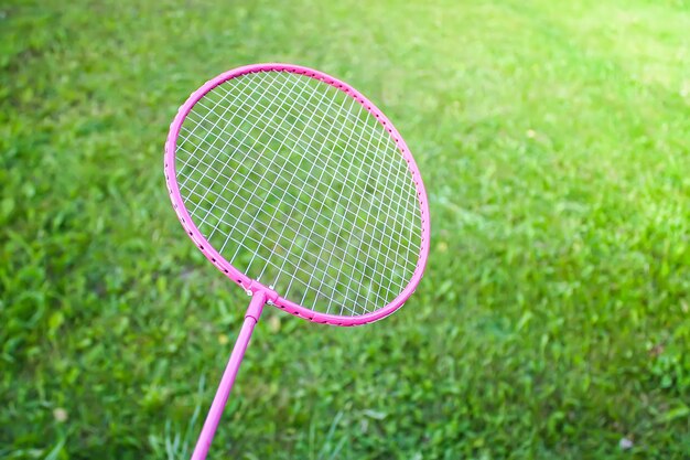 Badmintonschläger auf grünem Sommergrashintergrundabschluß oben.