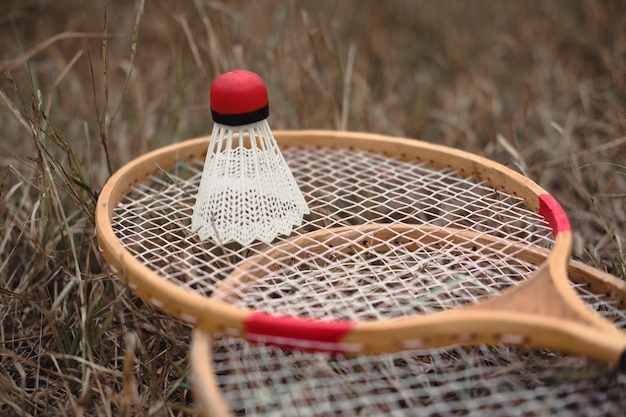 Badmintonschläger aus Holz und ein Federball aus weißem Kunststoff mit rotem Kopf Das Badmintonspiel