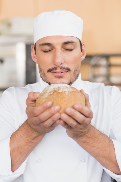 Bäcker, der ein frisch gebackenes Laib riecht