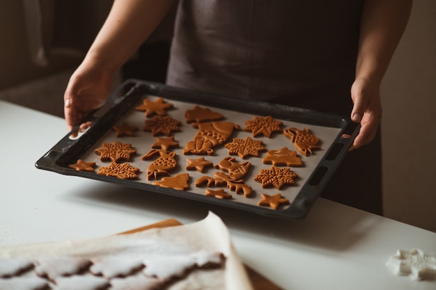 Bäcker hält ein Backblech mit Lebkuchenplätzchen