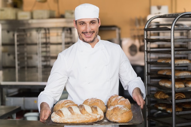 Bäcker hält Tablett mit Brot