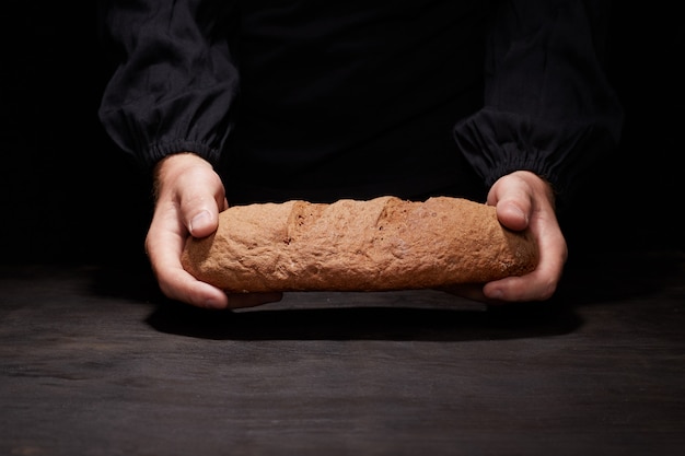 Bäcker Mann, der ein schönes rundes Brot hält
