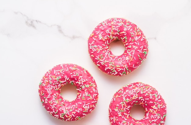 Bäckerei-Branding- und Café-Konzept gefrostet bestreute Donuts süßes Gebäckdessert auf Marmortischhintergrund Donuts als leckere Snack-Draufsicht-Lebensmittelmarke flach für Blog-Menü oder Kochbuch-Design