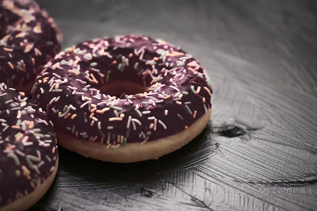 Bäckerei-Branding- und Café-Konzept gefrostet bestreute Donuts süßes Gebäckdessert auf rustikalem Holzback...