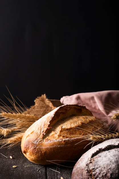 Bäckerei - Goldrustikale knusprige Brotlaibe und Brötchen auf schwarzem Hintergrund.