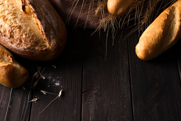 Bäckerei - Goldrustikale knusprige Brotlaibe und Brötchen auf schwarzem Hintergrund.