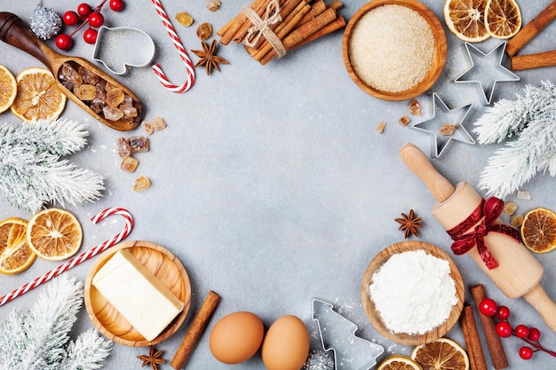 Foto bäckerei-hintergrund mit zutaten zum kochen weihnachtsbäckerei geschmückt mit tannenbaum mehlbrust