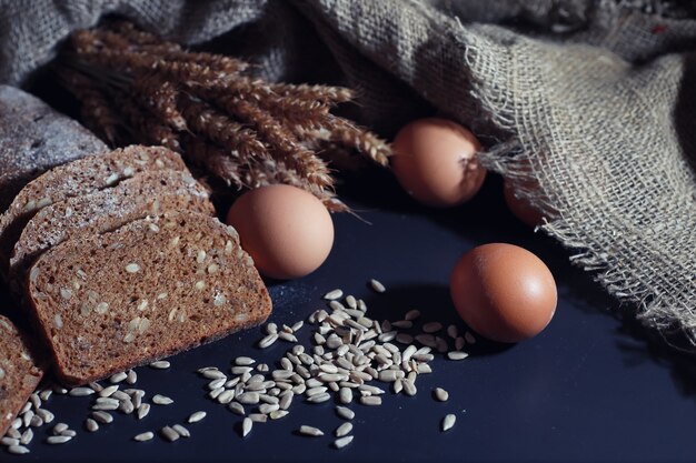 Bäckerei- und Lebensmittelkonzept. Frische, gesunde Roggen- und Weißbrotsorten essen Nahaufnahme. Frisches hausgemachtes Brot mit Getreide.