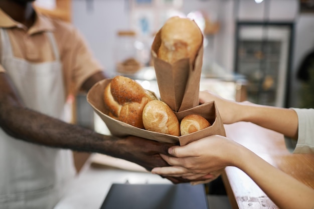 Bäckereiarbeiter, der dem Kunden Verpacker gibt