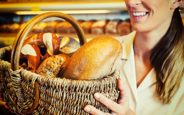 Bäckerfrau im Unterstützer, der Brot im Korb verkauft