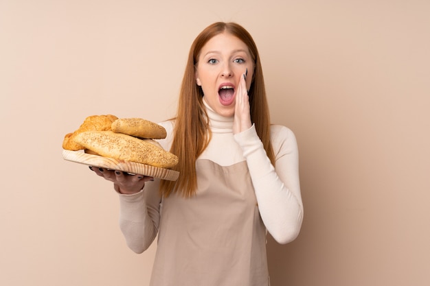 Bäckerin hält einen Tisch mit mehreren Broten, die mit weit geöffnetem Mund schreien