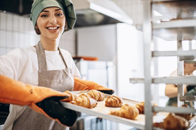 Bäckerin in der Küche mit frisch gebackenen Croisants