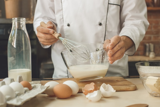 Bäckerkoch kocht backen in der Küche professioneller Zutaten hinzufügen