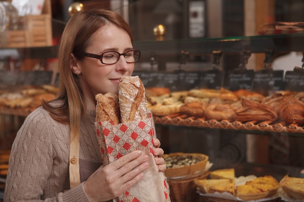 Baer hembras maduras disfrutando de oler pan recién horneado en su panadería