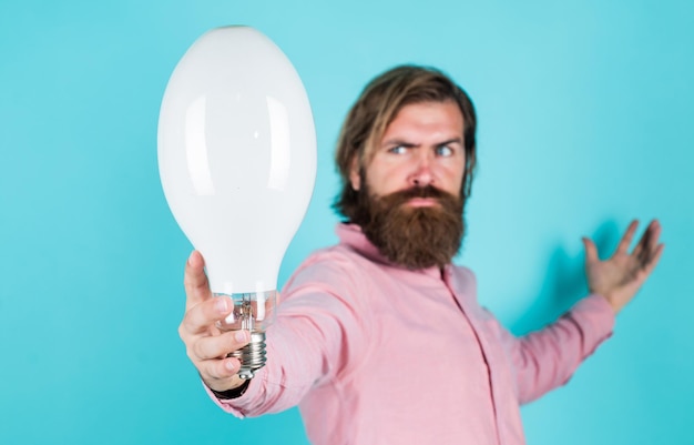 Foto bärtiger denkender mann hält glühbirne energiesparende innovative idee und innovation modernes denken lösung für probleme neuer ideengenerator geschäftsidee und kreativität symbol selektiver fokus