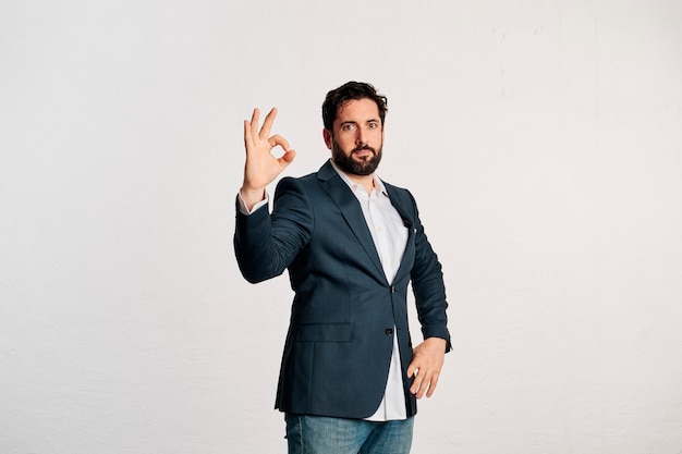 Bärtiger erwachsener Mann in Jacke und Hemd mit Kopienraum in einem Studio mit weißem Hintergrund gedreht.