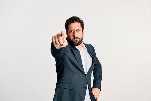 Bärtiger erwachsener Mann in Jacke und Hemd mit Kopienraum in einem Studio mit weißem Hintergrund gedreht.