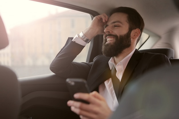 Bärtiger Geschäftsmann, der in ein Auto reist