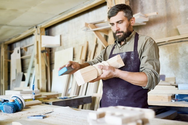 Bärtiger Handwerker in Arbeit eingewickelt