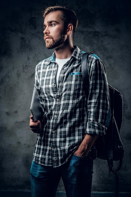 Bärtiger Hipster-Mann im Fleece-Shirt hält Tablet-PC auf grauem Hintergrund.