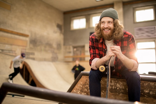 Foto bärtiger junger mann im skatepark