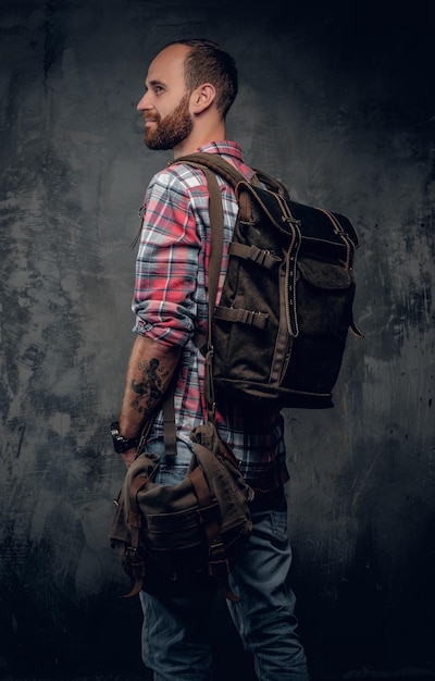 Bärtiger, lässiger Touristenmann mit Rucksack, der in die Ferne blickt.