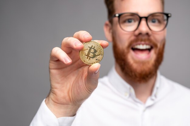 Bärtiger männlicher Investor, der Bitcoin zeigt