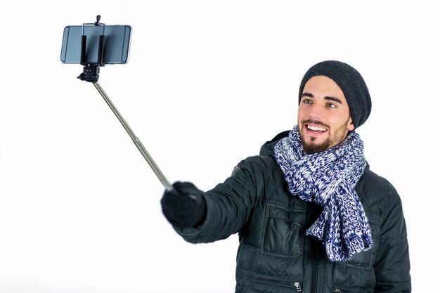 Bärtiger Mann, der einen selfie Stock verwendet