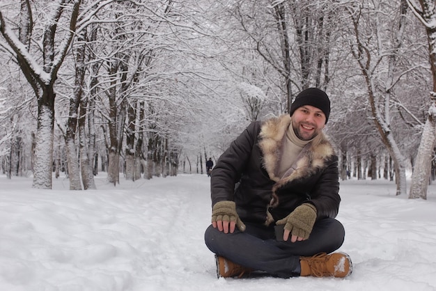 Bärtiger Mann, der in einer Winterpark-Schneesaison geht