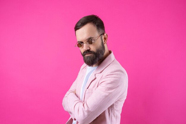 Bärtiger Mann in rosa Jacke mit Brille Emotionales Studioporträt
