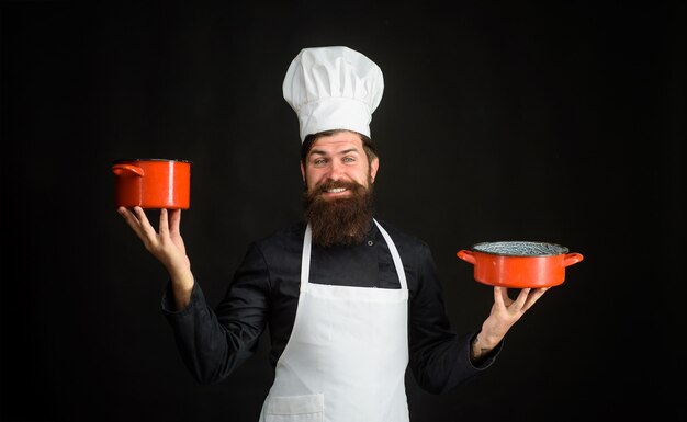 Bärtiger Mann Koch tragen Kochmütze und Uniform kochen Essen Beruf professioneller Koch Mann in Kochmütze