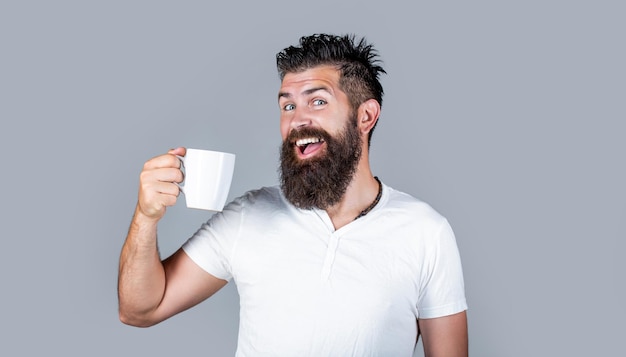 Bärtiger Mann lächelnd zeigt Zeichen ok Guten Morgen Mann Tee ok Lächelnder Hipster-Mann mit einer Tasse frischen Kaffee Glücklicher Mann Morgenkonzept