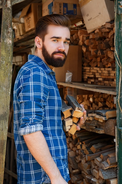 Foto bärtiger mann mit brennholz