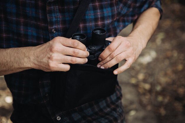 Bärtiger Mann mit Fernglas im Wald