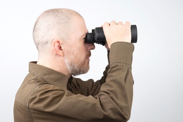 Foto bärtiger mann mit fernglas in den händen suchen