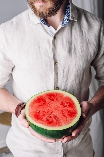 Bärtiger Mann mit halber Wassermelone