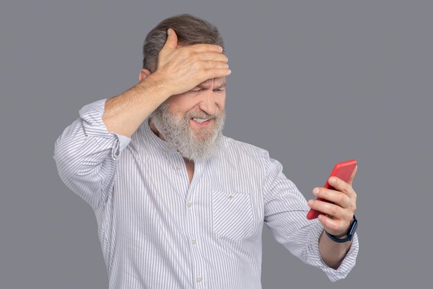 Bärtiger Mann mit Smartphone in der Hand