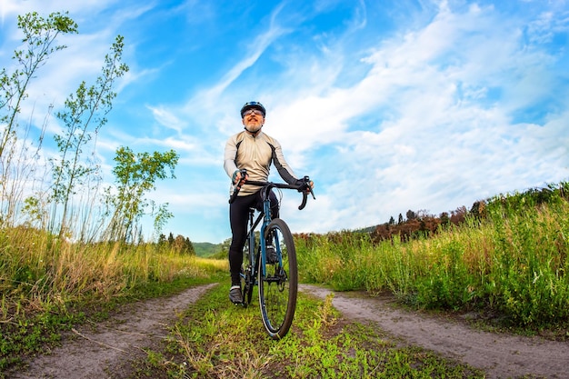 Foto bärtiger mann radfahrer fährt fahrrad auf einer straße in der natur sport hobbys und unterhaltung für die gesundheit