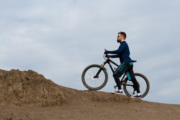 Bärtiger Mountainbiker fährt Berge