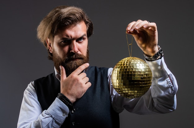 Foto bärtiger reifer mann hält goldene discokugel, partyeinladungskonzept.